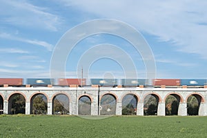 Blurry wagons of freight train goes very fast through the viaduct, Czech Republic