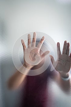 Blurry woman hand behind frosted glass metaphor panic and negative dark emotional