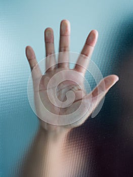 Blurry woman hand behind frosted glass metaphor panic and negative dark emotional