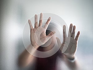 Blurry woman hand behind frosted glass metaphor panic and negative dark emotional