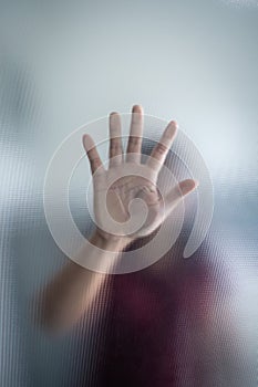 Blurry woman hand behind frosted glass metaphor panic and negative dark emotional