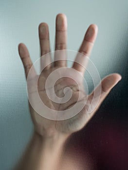 Blurry woman hand behind frosted glass metaphor panic and negative dark emotional