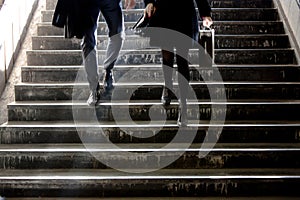 Blurry young man and woman going down the subway stairs