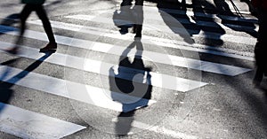 Blurry zebra crossing with pedestrians making long shadows