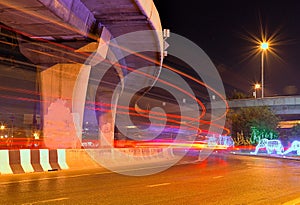 Blurs the traffic flow in the city night lights of a car under the freeway .