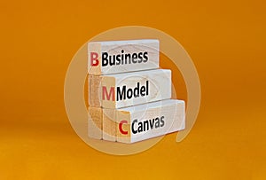 BMC business model canvas symbol. Concept words BMC business model canvas on blocks on a beautiful orange table, orange background