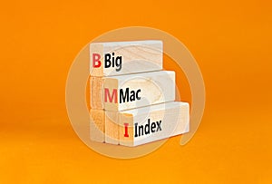 BMI big mac index symbol. Concept words BMI big mac index on wooden blocks on a beautiful orange table orange background. Business