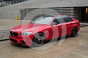 BMW 5 series F10 car is parked near office building