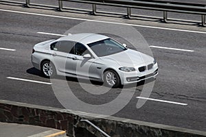 BMW white speeding on empty highway