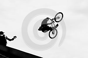 BMX bike jumping in the sky on high speed, black and white silhouette. Extrem Sport photo