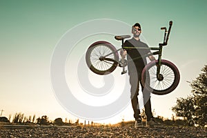 Bmx bike rider in a sunset. Guy riding a bmx bike