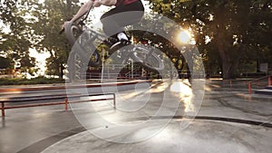 Bmx biker exercising with his bike outdoors, making hard side bike bounce in skate park, doing tricks on beautiful