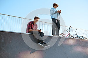 Bmx bikers, teenagers leisures on ramp, skatepark