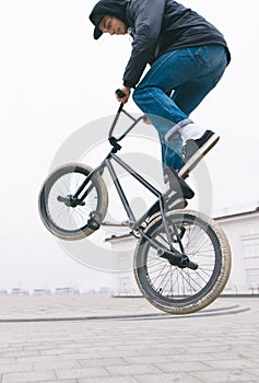 BMX freestyle close up. young man makes stunts on a BMX bike.Street culture