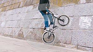 BMX freestyle. Stunts on BMX bike. BMX rider rides along a curve wall