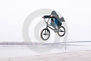 BMX freestyle. toddler jumps on a BMX bike. BMX rider makes tricks on the background of the river