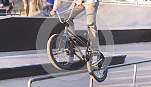 Bmx Rider is doing tricks on the park skate. A cyclist slides along the rails on a BMX bike