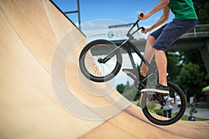 Bmx rider jumping over on a U ramp in a skatepark