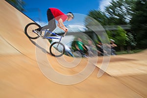 Bmx rider jumping over on a U ramp in a skatepark