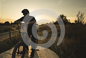 BMX rider at sunset. Guy riding a bmx bike