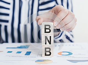 BNB word by wooden block words on white paper background. BNB or Binance in concept of digital money, cryptocurrency and business