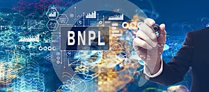 BNPL - Buy Now Pay Later theme with businessman in a bokeh neon light trails city background