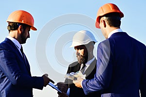 Board of architects with interested faces in suits and helmets