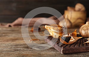 Board with black garlic on wooden table