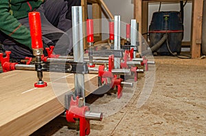 Board with clamps in a carpentry workshop. Joinery work. Carpenter