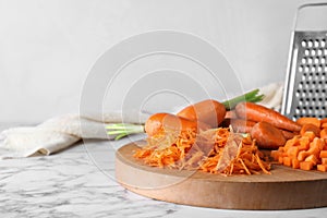 Board with differently cut carrots on marble table