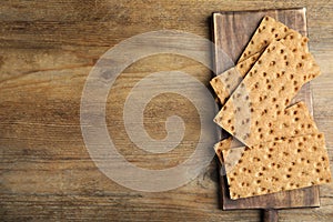 Board with fresh rye crispbreads on wooden table, top view. Space for text