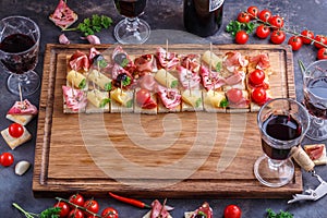 Board full of pinxtos or tapas with jamon, ham and cheese, copyspace