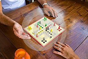 Board-game being played by a guy and a girl on a wooden table. photo
