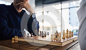 Board game, chess and men playing at a table in office while thinking of strategy or plan. Male friends together to play