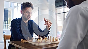 Board game, chess and men playing at a table while talking strategy or plan. Business partners or friends together to