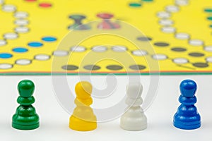 Board game with different colored game pawns on it. Ludo or Sorry board game play figures