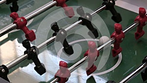 Board game of football soccer. Foosball. Closeup of the hand of a child throwing the ball on the field with football