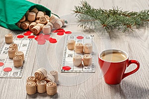 Wooden lotto barrels with bag, game cards, red chips, cup of coffee and Christmas fir tree branches