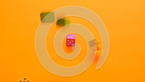 Board games concept. games of chance. Multicolored cubes slowly fall on a orange background