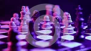 Board intelligence game - wooden chess under neon colorful light and smoke. Close-up view of pieces on chessboard on