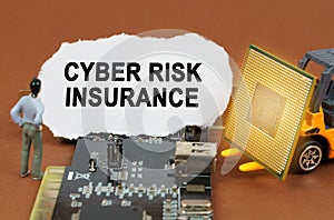 On the board with microcircuits lies a paper plate with the inscription - Cyber Risk Insurance