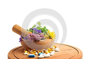 Board with mortar, fresh herbs and pills on white background