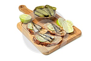 Board with sandwiches with sprats isolated on white background