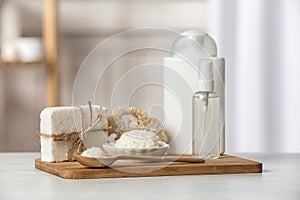 Board with Shea butter and cosmetic products on table indoors.