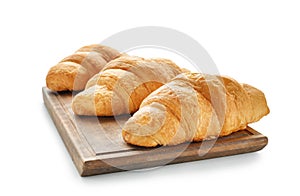Board with tasty croissants on white background