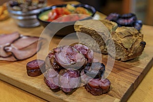 Board of traditional Portuguese food with blood and pork sausage, ham, bread, olives at a restaurant in Porto, Portugual