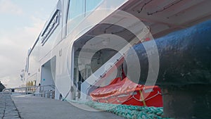 Board of white passenger ship near concrete pier. Close up view.