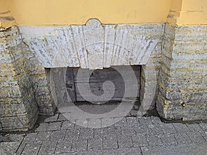 boarded up basement window of the building view from the street.