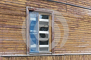 Boarded up window on weathered wooden wall