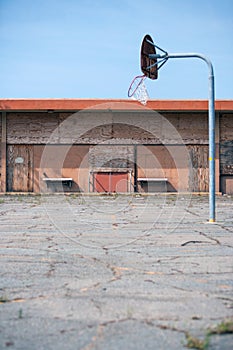 Boarded up building and abandoned old basketball court